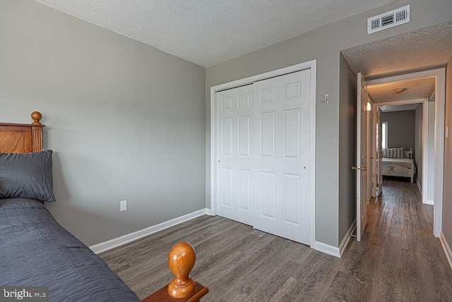 611 142nd St Unit 202, Ocean City, MD 21842 - bedroom with wood finished floors, baseboards, a closet, and a textured ceiling