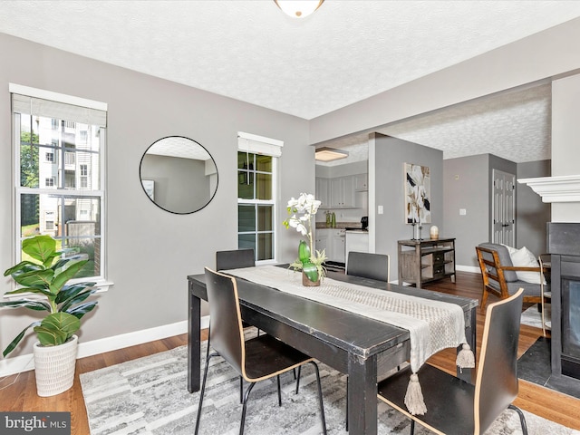 6505 Springwater Ct Unit 7103, Frederick, MD 21701 - dining space featuring baseboards, a textured ceiling, a fireplace, and wood finished floors