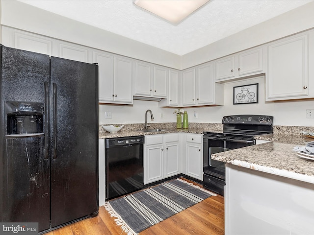 6505 Springwater Ct Unit 7103, Frederick, MD 21701 - kitchen with black appliances, a sink, light wood finished floors, and light stone counters