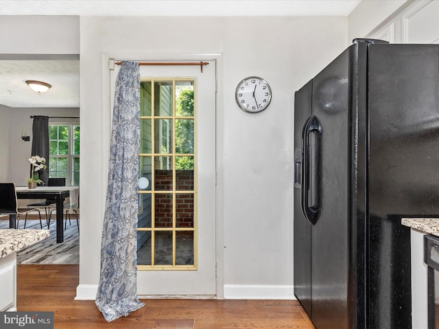6505 Springwater Ct Unit 7103, Frederick, MD 21701 - kitchen with black fridge with ice dispenser, wood finished floors, baseboards, and light stone countertops