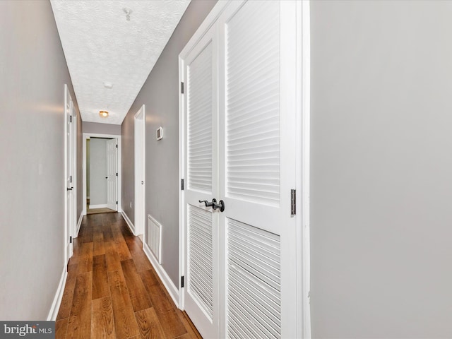 6505 Springwater Ct Unit 7103, Frederick, MD 21701 - hallway featuring a textured ceiling, wood finished floors, and baseboards