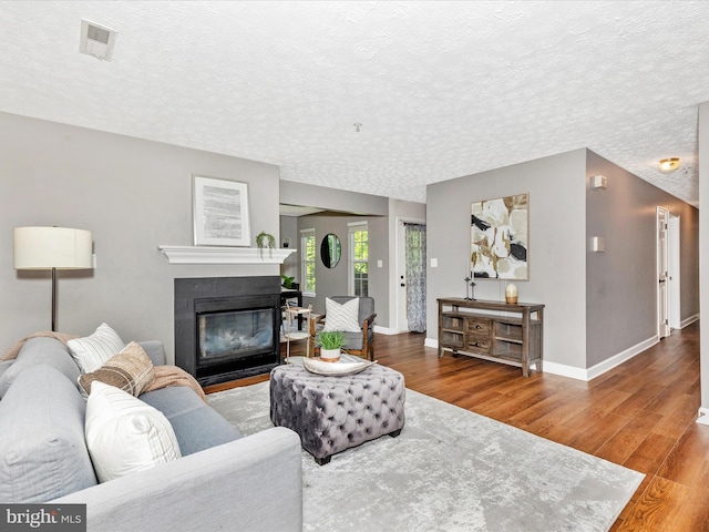 6505 Springwater Ct Unit 7103, Frederick, MD 21701 - living room featuring a textured ceiling, wood finished floors, baseboards, and a fireplace with flush hearth