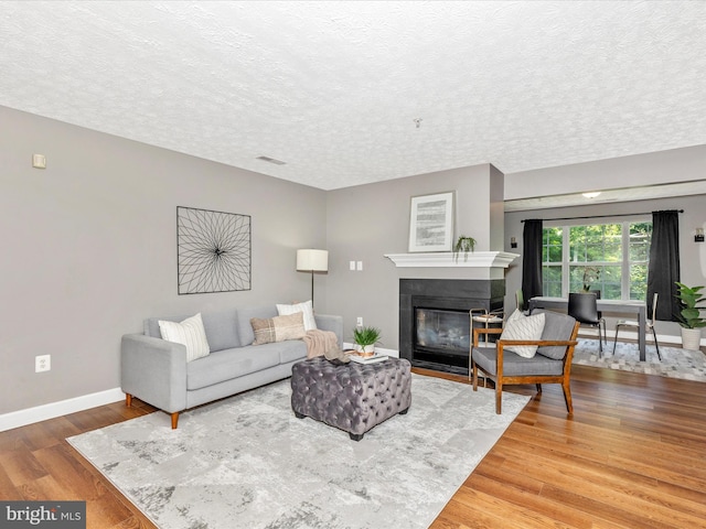 6505 Springwater Ct Unit 7103, Frederick, MD 21701 - living room with a textured ceiling, a fireplace with flush hearth, baseboards, and wood finished floors
