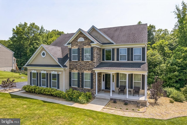 2058 Baythorne Rd, Prince Frederick, MD 20678 - view of front of home with stone siding, a porch, a front lawn, and a shingled roof