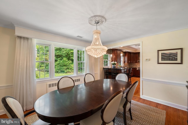 653 Broad Acres Rd, Penn Valley, PA 19072 - dining area with a chandelier, wood finished floors, crown molding, radiator, and baseboards