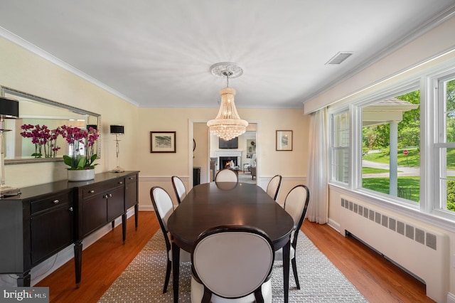 653 Broad Acres Rd, Penn Valley, PA 19072 - dining area featuring radiator, wood finished floors, a wainscoted wall, crown molding, and a chandelier