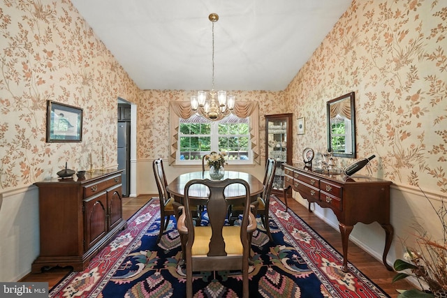 3382 Flint Hill Pl, Woodbridge, VA 22192 - dining room with lofted ceiling, wallpapered walls, a chandelier, wood finished floors, and a wainscoted wall