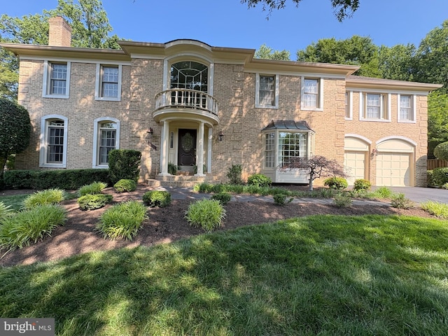 9111 Oak Chase Ct, Fairfax Station, VA 22039 - colonial house with a balcony, a chimney, driveway, a garage, and brick siding