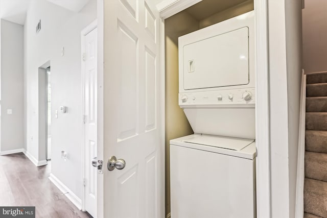 3851 Aristotle Ct Unit 1-412, Fairfax, VA 22030 - washroom featuring stacked washing machine and dryer and wood finished floors