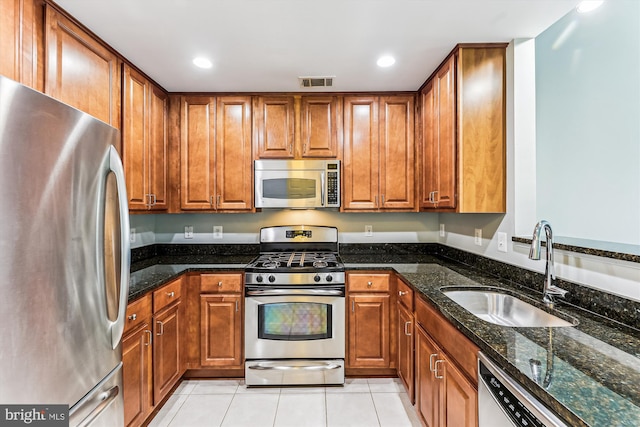 3851 Aristotle Ct Unit 1-412, Fairfax, VA 22030 - kitchen featuring stainless steel appliances, brown cabinets, recessed lighting, dark stone countertops, and light tile patterned floors