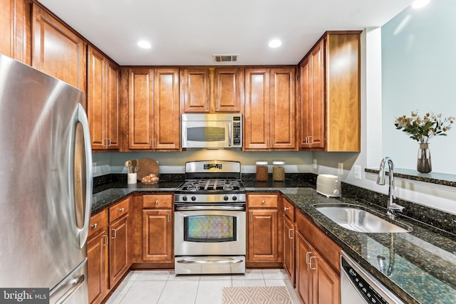 3851 Aristotle Ct Unit 1-412, Fairfax, VA 22030 - kitchen featuring appliances with stainless steel finishes, brown cabinets, light tile patterned flooring, recessed lighting, and dark stone counters
