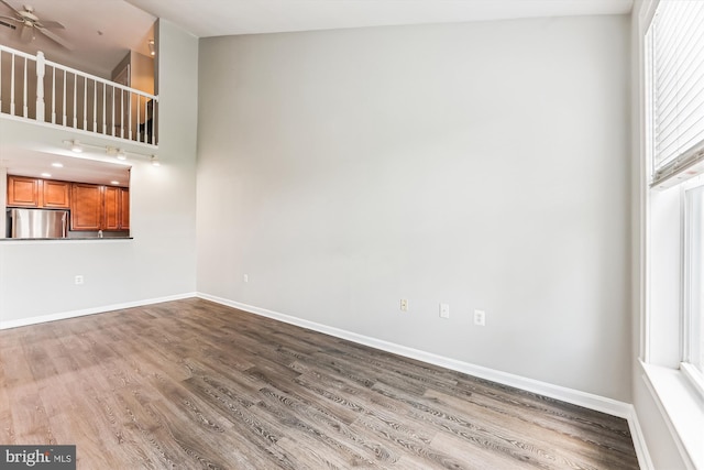 3851 Aristotle Ct Unit 1-412, Fairfax, VA 22030 - unfurnished living room featuring wood finished floors, a high ceiling, and ceiling fan