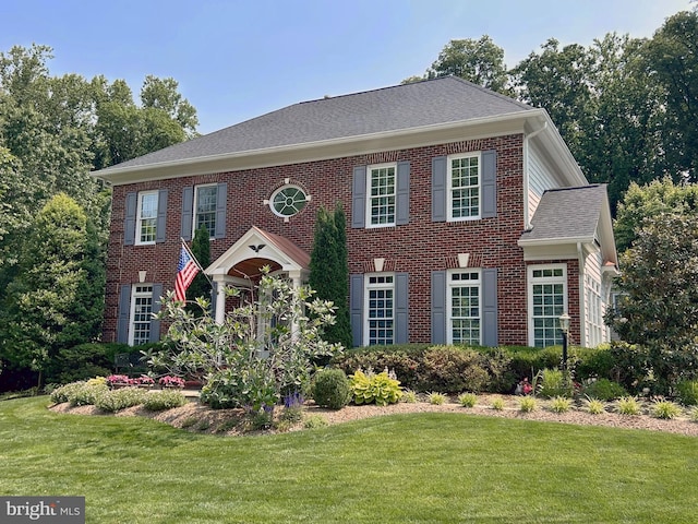 6321 Wilmington Dr, Burke, VA 22015 - georgian-style home featuring a front lawn, brick siding, and a shingled roof