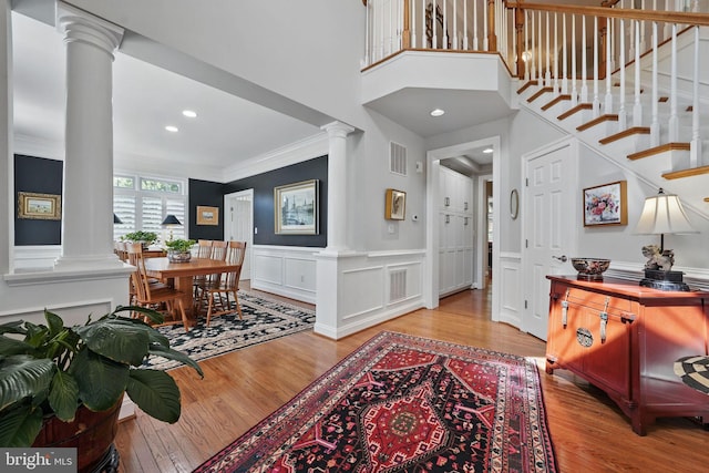 6321 Wilmington Dr, Burke, VA 22015 - foyer featuring decorative columns, crown molding, wood finished floors, a wainscoted wall, and recessed lighting