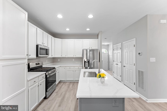 45571 Reading Ter, Sterling, VA 20166 - kitchen featuring appliances with stainless steel finishes, a sink, light wood-style floors, an island with sink, and recessed lighting
