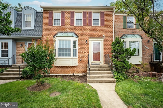 3134 Borge St, Oakton, VA 22124 - townhome / multi-family property featuring brick siding, a shingled roof, and a front lawn