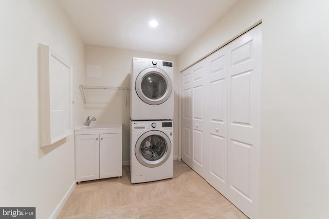 3134 Borge St, Oakton, VA 22124 - laundry area featuring stacked washer and clothes dryer, cabinet space, and light tile patterned flooring