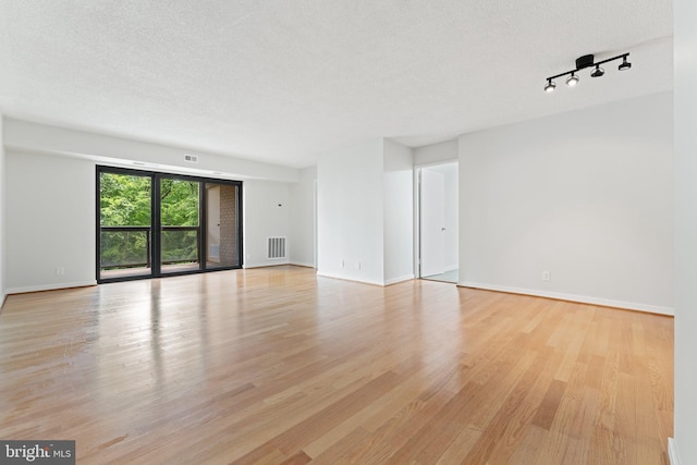 203 Yoakum Pkwy Unit 603, Alexandria, VA 22304 - empty room with light wood-style floors, a textured ceiling, baseboards, and rail lighting