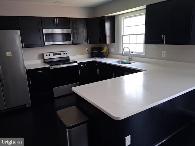 13017 Broadmore, Silver Spring, MD 20904 - kitchen with stainless steel appliances, a sink, dark cabinets, light countertops, and a peninsula