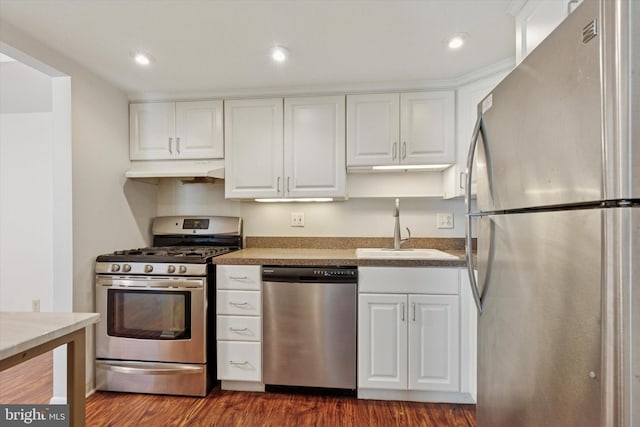 212 Old Forge Xing, Devon, PA 19333 - kitchen with stainless steel appliances, under cabinet range hood, white cabinetry, dark wood-type flooring, and recessed lighting