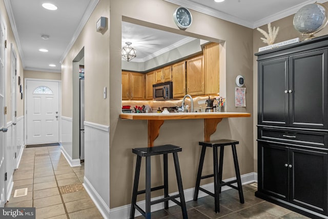 48 Deer Run Rd, Perkasie, PA 18944 - kitchen featuring stainless steel microwave, light tile patterned flooring, a kitchen breakfast bar, ornamental molding, and light countertops