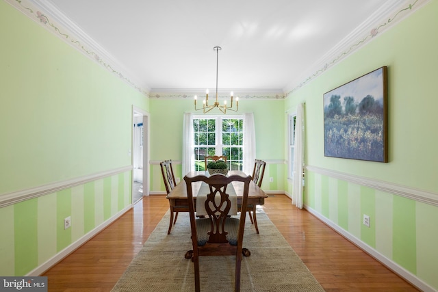 18722 Timoney Ct, Leesburg, VA 20176 - dining room featuring wood finished floors, a chandelier, ornamental molding, wallpapered walls, and wainscoting