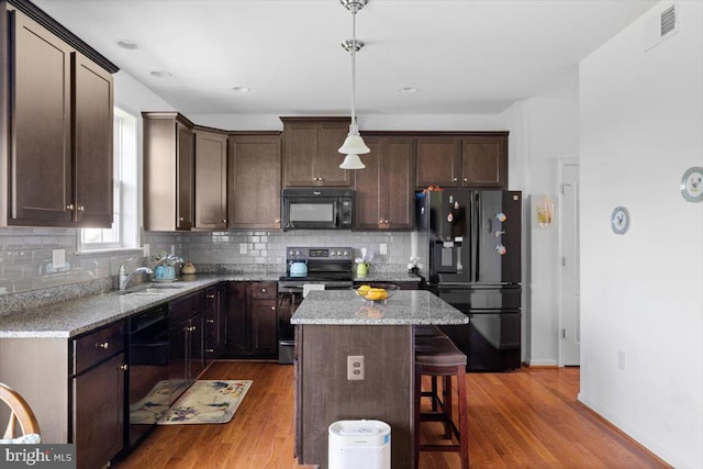 100 Taylor Ct, Stephenson, VA 22656 - kitchen with black appliances, dark brown cabinetry, decorative backsplash, a kitchen bar, and recessed lighting