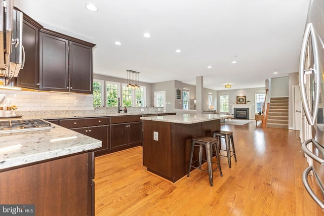 2304 Kings Forest Trl, Mount Airy, MD 21771 - kitchen featuring a breakfast bar area, recessed lighting, light wood-type flooring, decorative backsplash, and dark brown cabinetry