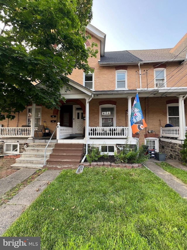 713 Juniper St, Quakertown, PA 18951 - view of property featuring covered porch, brick siding, and a front yard