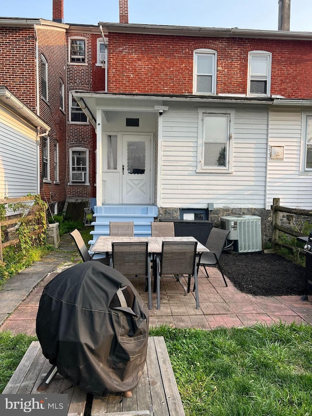 713 Juniper St, Quakertown, PA 18951 - back of house featuring central AC unit, a chimney, entry steps, a patio area, and brick siding