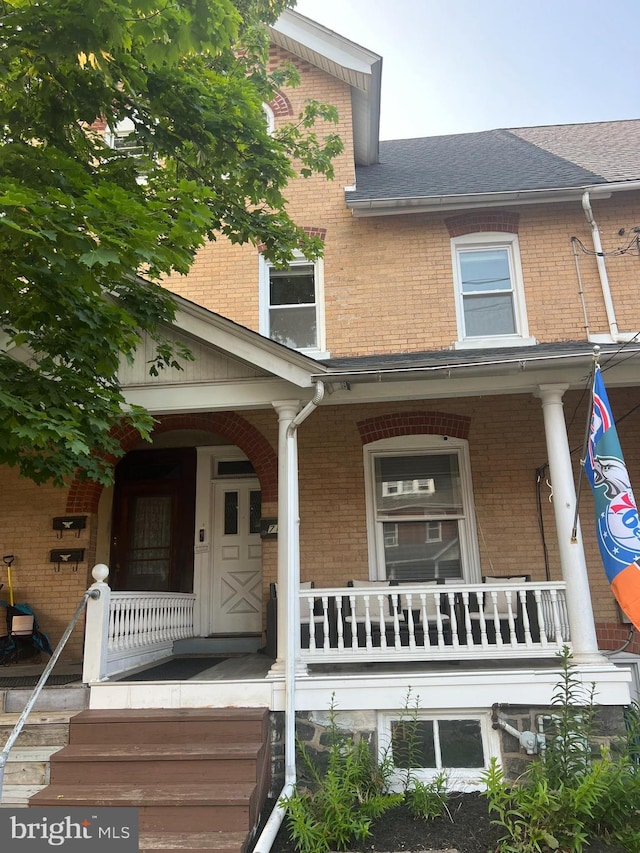 713 Juniper St, Quakertown, PA 18951 - view of front of home with brick siding, covered porch, and roof with shingles
