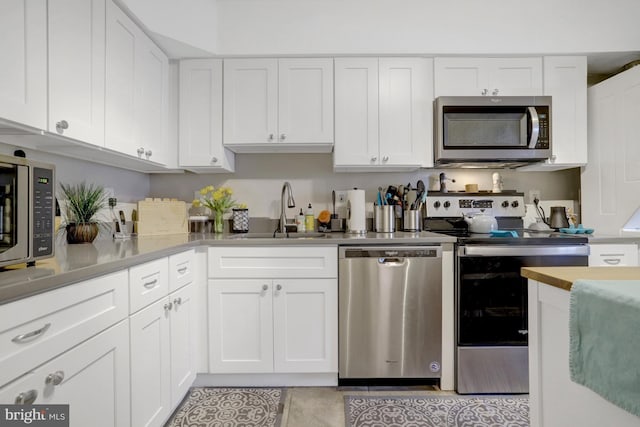 3713 S George Mason Dr Unit 713, Falls Church, VA 22041 - kitchen featuring appliances with stainless steel finishes, a sink, light tile patterned flooring, white cabinetry, and light countertops