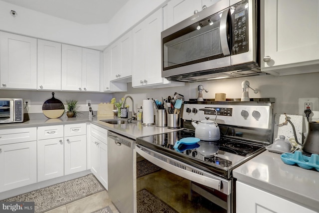 3713 S George Mason Dr Unit 713, Falls Church, VA 22041 - kitchen featuring appliances with stainless steel finishes, a sink, light countertops, white cabinetry, and light tile patterned flooring