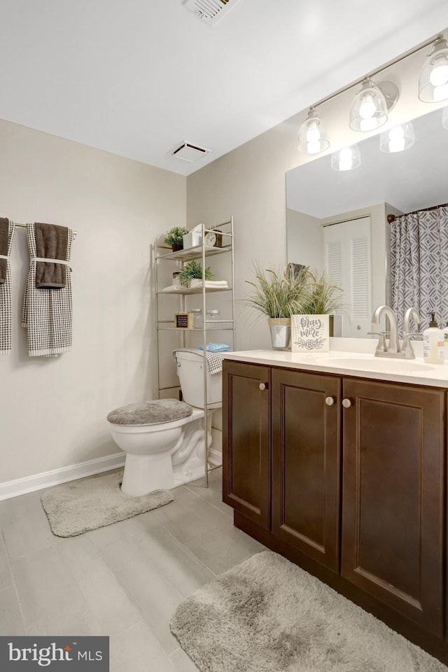 3713 S George Mason Dr Unit 713, Falls Church, VA 22041 - bathroom with toilet, vanity, and baseboards