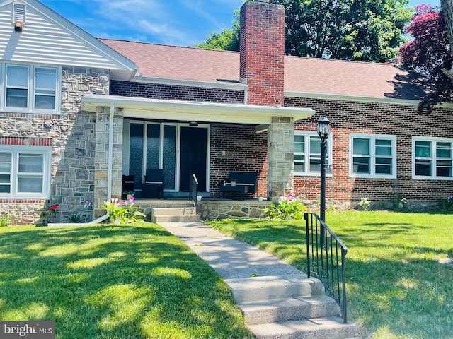 2719 Park St, Reading, PA 19606 - view of front facade with a chimney, a front yard, stone siding, and roof with shingles