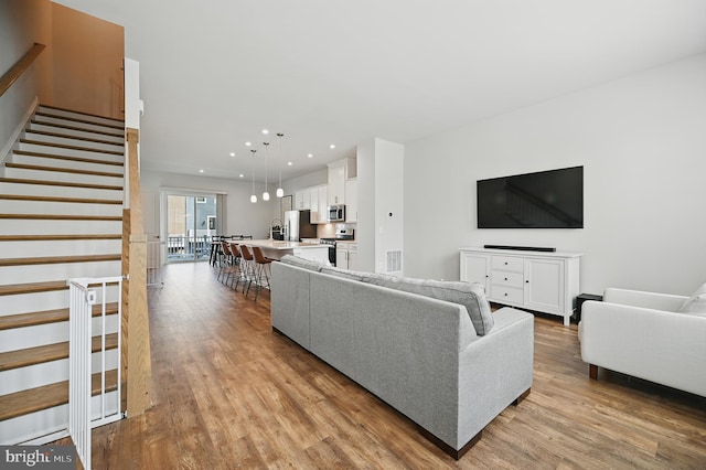 1763 Hickory Woods Rd, Dumfries, VA 22026 - living room featuring wood finished floors, stairs, and recessed lighting
