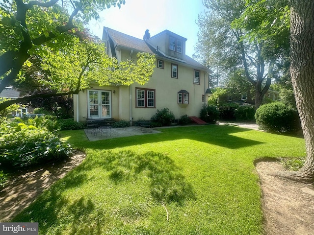 607 Harper Ave, Drexel Hill, PA 19026 - back of property featuring a lawn, stucco siding, and a patio area