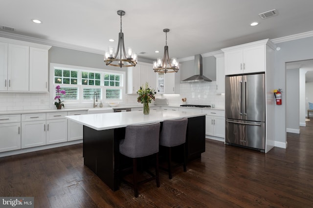 58 Haas Rd, Basking Ridge, NJ 07920 - kitchen with high end refrigerator, wall chimney exhaust hood, a chandelier, ornamental molding, and white cabinets