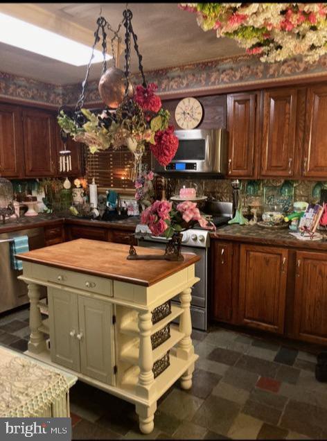 1397 Dennis Rd, Southampton, PA 18966 - kitchen with wood counters, stainless steel appliances, dark flooring, a center island, and tasteful backsplash