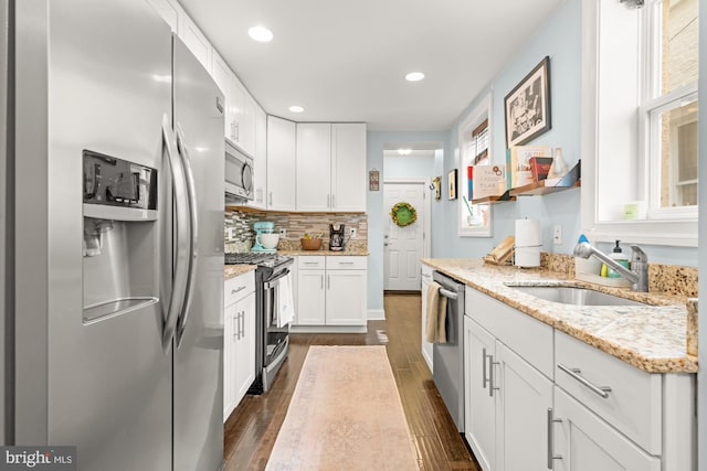 206 E Randall St, Baltimore, MD 21230 - kitchen with appliances with stainless steel finishes, a sink, dark wood-style floors, white cabinetry, and tasteful backsplash