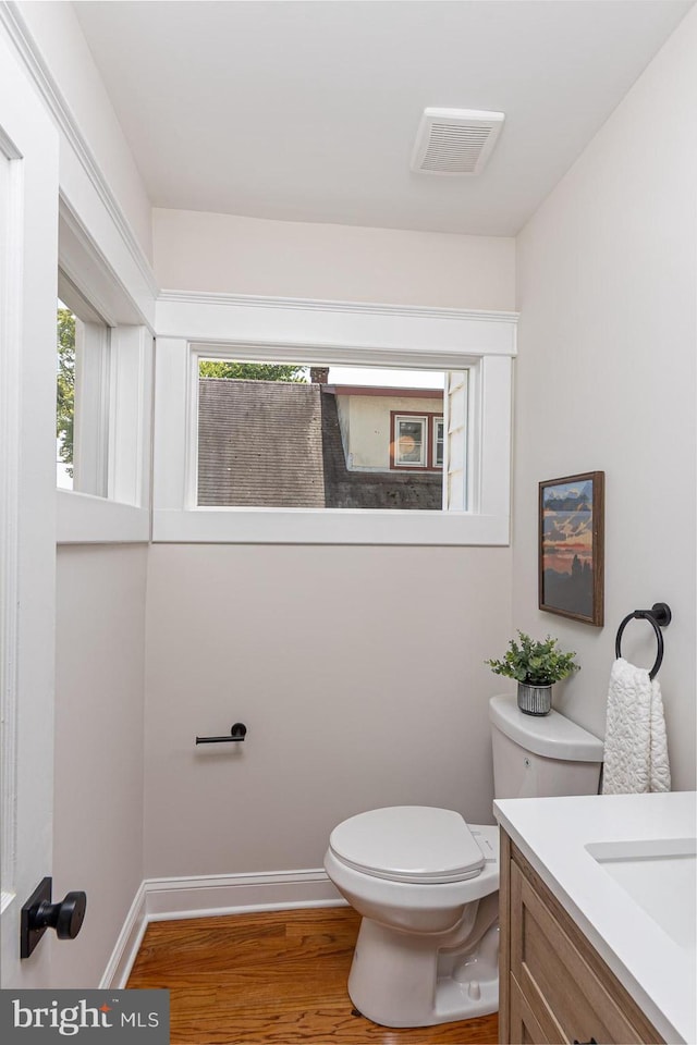 2912 Bauernwood Ave, Baltimore, MD 21234 - bathroom with wood finished floors, toilet, vanity, and baseboards