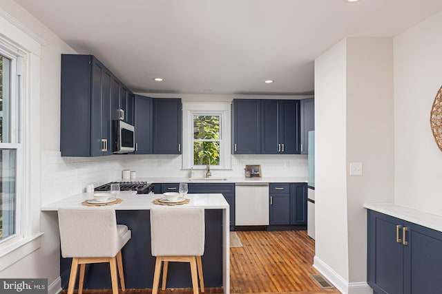 2912 Bauernwood Ave, Baltimore, MD 21234 - kitchen with appliances with stainless steel finishes, a sink, a breakfast bar area, backsplash, and recessed lighting