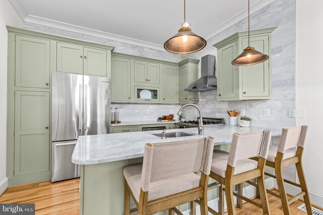 1235 S St NW Unit 1, Washington, DC 20009 - kitchen with green cabinets, wall chimney range hood, freestanding refrigerator, light wood finished floors, and a peninsula