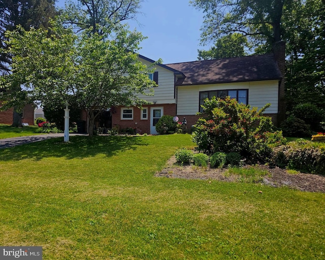1510 Springside Dr, Lancaster, PA 17603 - tri-level home with brick siding, a front lawn, and a chimney