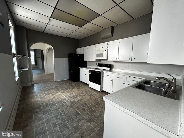 342 S 4th St, Reading, PA 19602 - kitchen with electric range oven, white microwave, a sink, freestanding refrigerator, and arched walkways