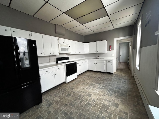 342 S 4th St, Reading, PA 19602 - kitchen featuring freestanding refrigerator, white microwave, range with electric cooktop, a sink, and a paneled ceiling