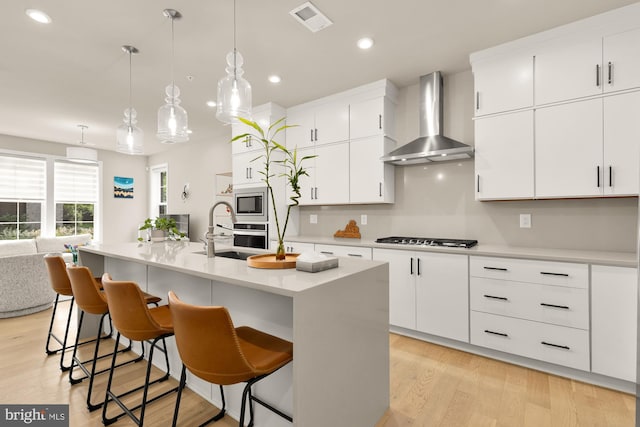 7458 Backett Wood Ter Unit 401, Mclean, VA 22102 - kitchen with wall chimney exhaust hood, a sink, stainless steel appliances, a kitchen breakfast bar, and recessed lighting