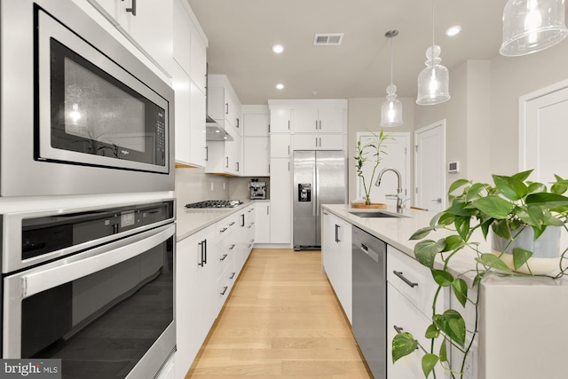 7458 Backett Wood Ter Unit 401, Mclean, VA 22102 - kitchen featuring a sink, stainless steel appliances, light countertops, light wood finished floors, and recessed lighting