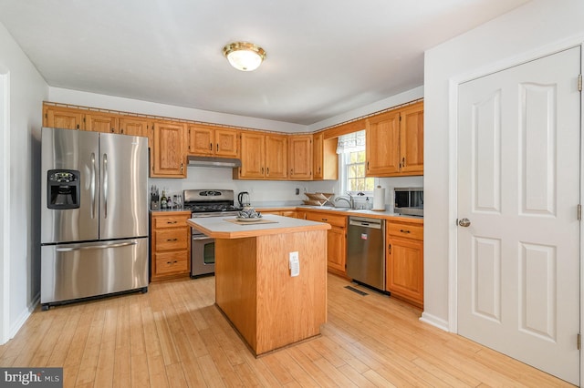349 Lexington Way, Littlestown, PA 17340 - kitchen featuring stainless steel appliances, under cabinet range hood, light countertops, a kitchen island, and light wood-style flooring