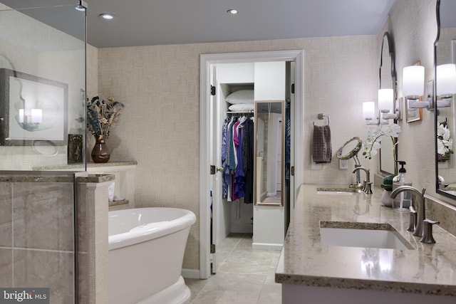 110 N Duke St Unit 201, Lancaster, PA 17602 - bathroom featuring double vanity, a soaking tub, a walk in closet, tile patterned flooring, and baseboards